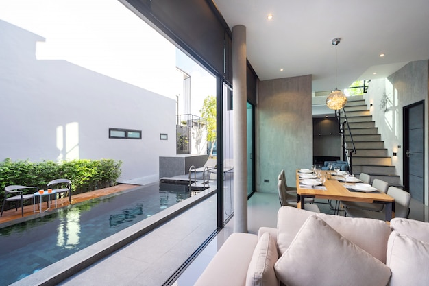 Dining table in loft design and open space to pool access