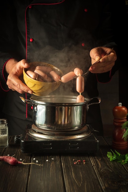 For dinner need to cook delicious meat sausages in a saucepan Chef in the kitchen at work