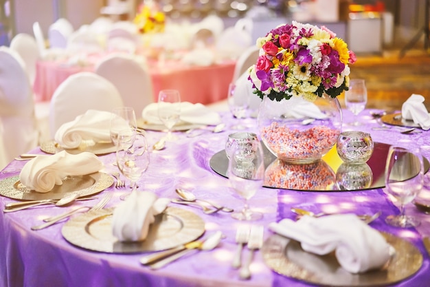 Dinner table setting with a glass vase of flower bouquet decoration