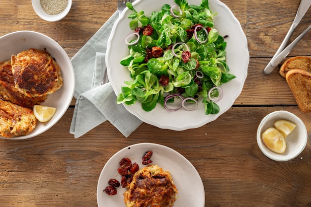 Dinner table with bowl green salad cutlets Rustic style