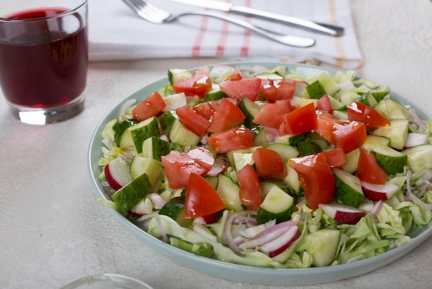 Dinner table with vegetable salad and red wine in a glass