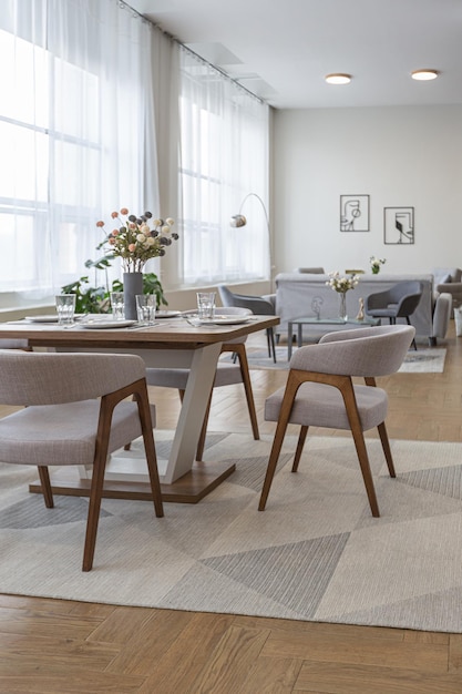 Dinnig and kitchen area in minimalist modern interior design huge bright apartment with an open plan in Scandinavian style in white blue and dark blue colors with columns in the center