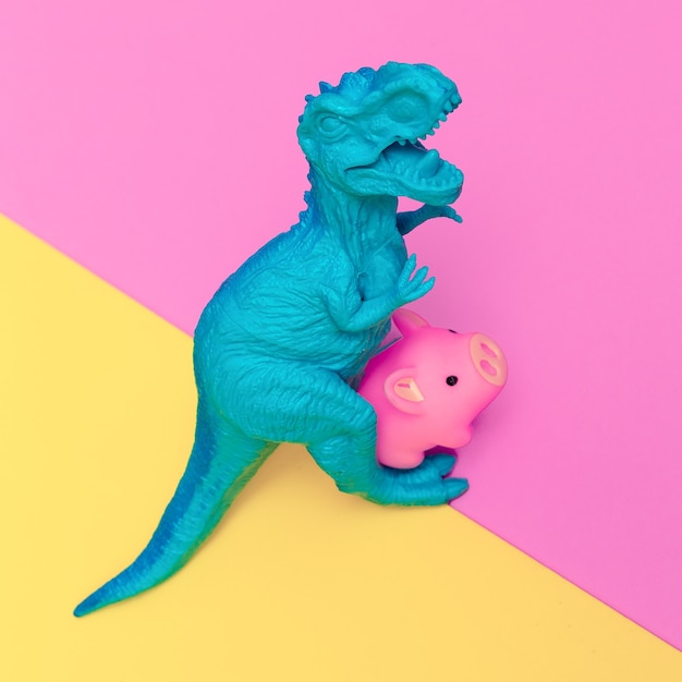 Dinosaur and piggy  toys on colored background. Minimal flat lay art.