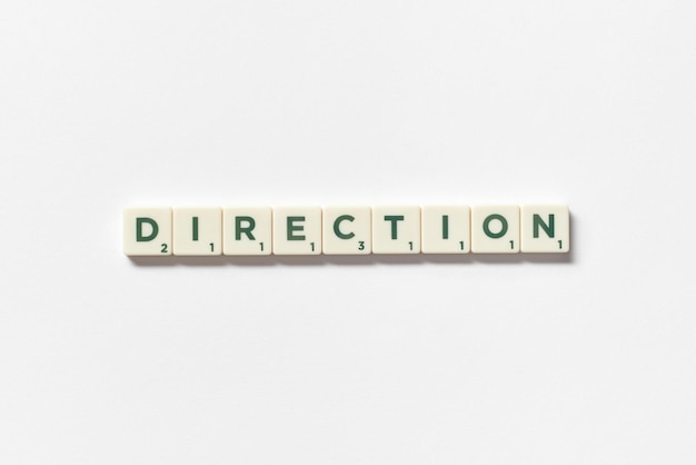 Direction formed of scrabble blocks on white background