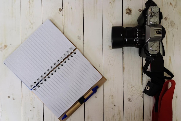 Photo directly above shot of camera and diary on wooden table