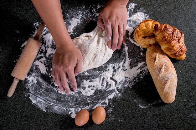 Photo directly above shot of hands kneading dough on table