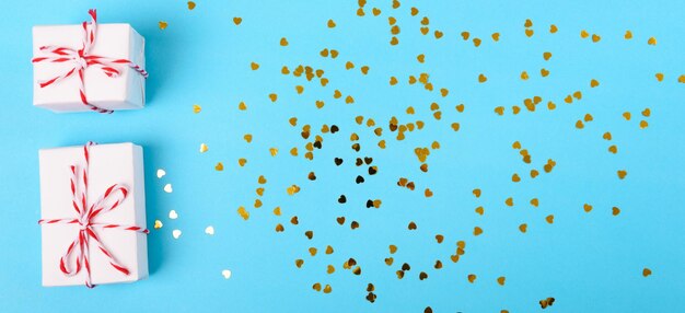 Photo directly above view of confetti and gifts against blue background