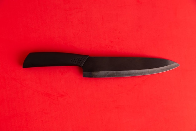 Photo directly above view of knife on red background