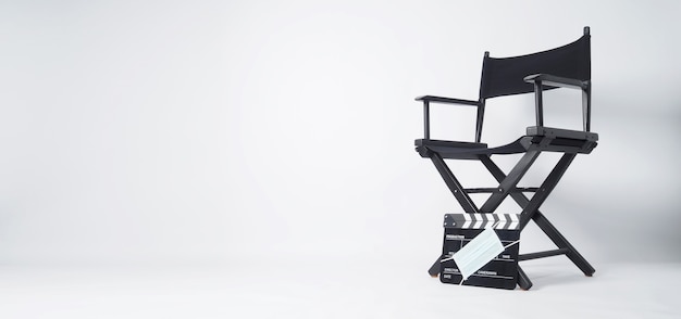 Director chair and black Clapper board or movie slate with face mask. it use in video production and cinema industry on white background.