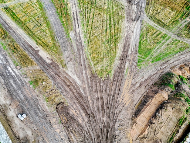 Dirt road after rain at the construction site View from above Drone photography Access road developed by heavy machinery