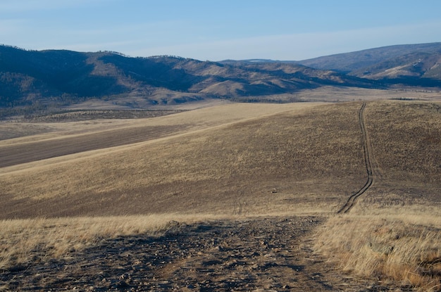 Dirt road through the hills Autumn mountainous terrain in the steppe through which the road runs