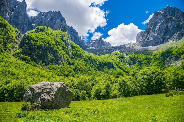 A dirt road through a picturesque plain among the high mountains.