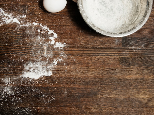 Dirty cooking table with flour and bowl, eggs food concept, top view copy space