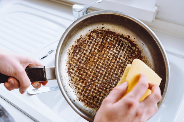 Dirty dishes with burnt food, household chores, washing dishes