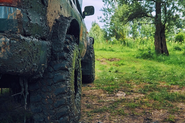 Dirty SUV is standing on the lawn after an offroad race covered in slush