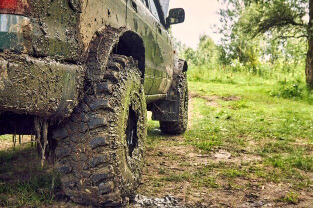 Dirty SUV is standing on the lawn after an offroad race covered in slush