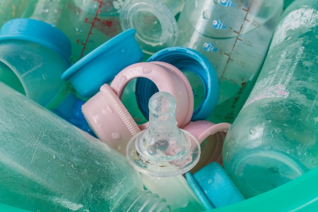 Dirty teats and bottles in a bucket of blue plastic.