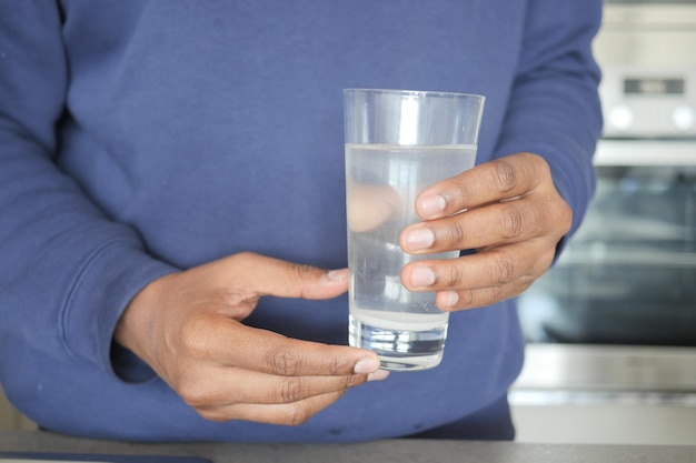 Dirty water pouring from a faucet tap in a glass