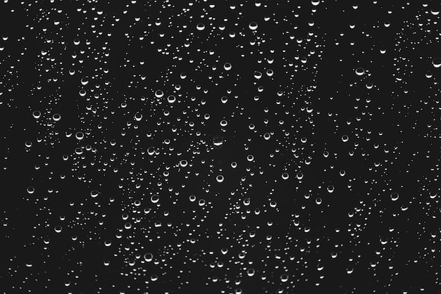 Dirty window with drops of rain. Atmospheric monochrome dark background with raindrops.