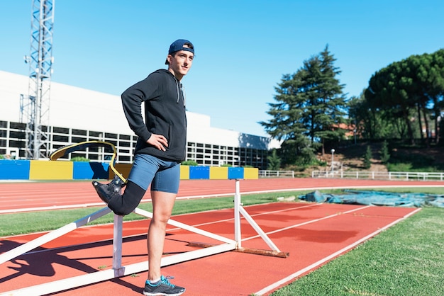 Disabled man athlete stretching with leg prosthesis. Disabled Sport Concept