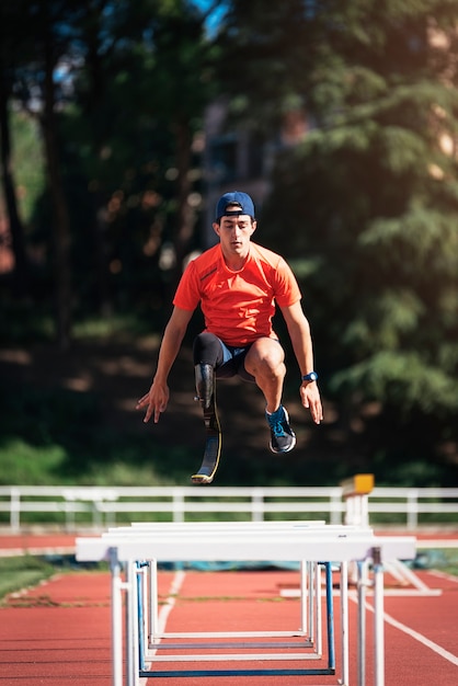 Disabled man athlete training with leg prosthesis. Paralympic Sport Concept.