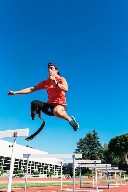 Disabled man athlete training with leg prosthesis. Paralympic Sport Concept.