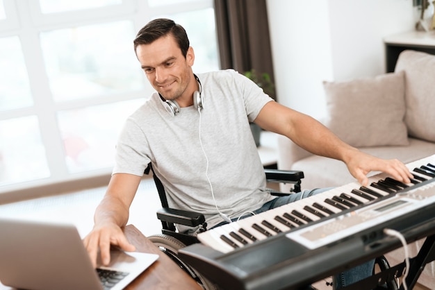 Disabled Man Composing Song with Electric Piano.