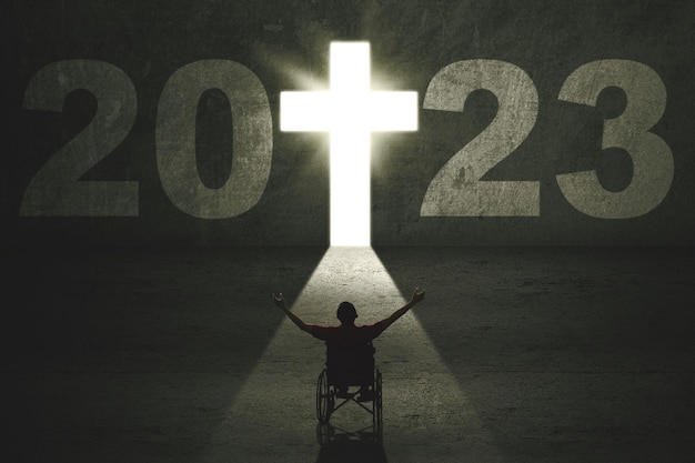 Disabled man look numbers 2023 with cross symbol