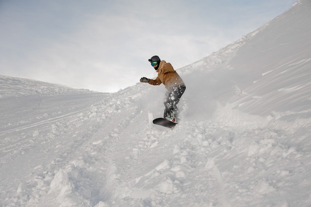 Disabled man without one hand riding on the snowboard on the ski slope in the popular tourist resort Gudauri in Georgia