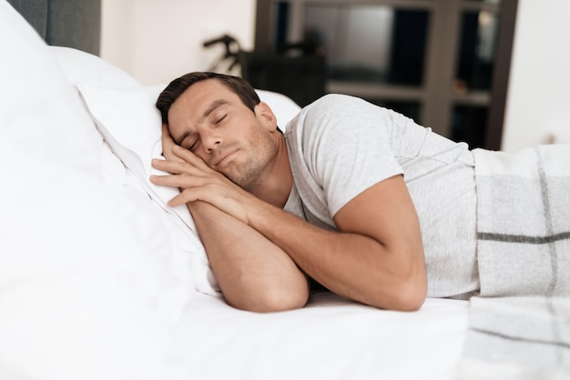 Disabled Person Sleeps in Bed With White Linens.