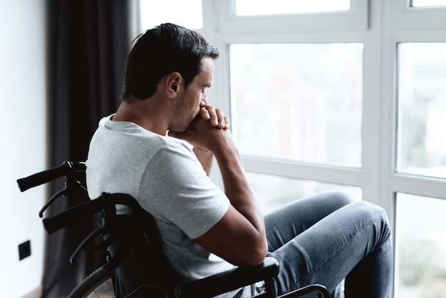 Disabled Person in Wheelchair Looking at Window.