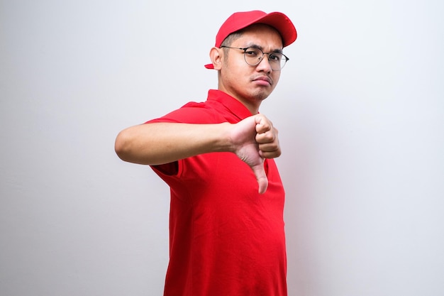 Disappointed asian delivery man in red tshirt and cap express dislike and bad attitude