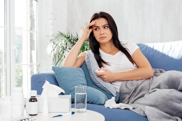 Disappointed female looking away while resting at home during illness