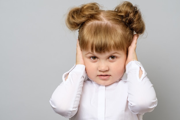 Disappointed little girl covering her ears