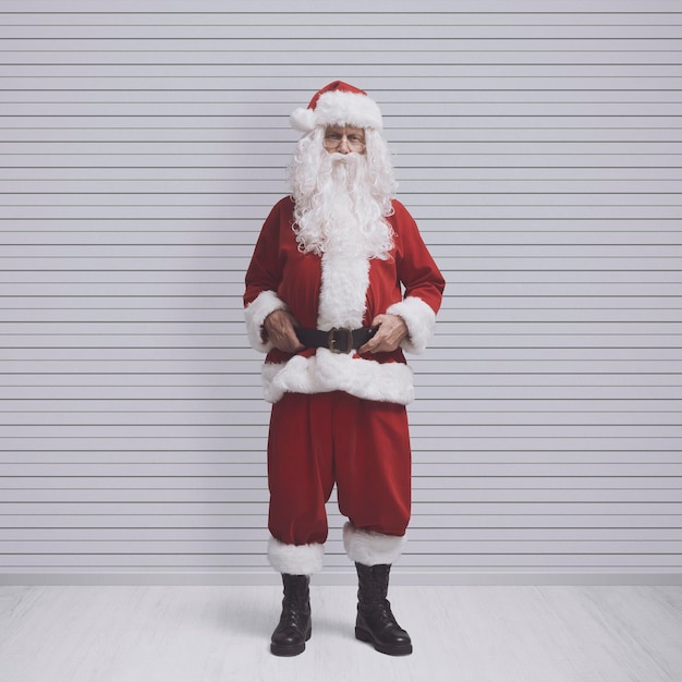 Photo disappointed santa claus posing for a mugshot at the police department