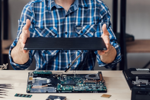 Disassembling computer by man in repair shop