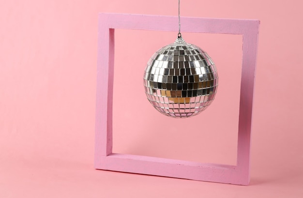 Disco ball with frame on pink background Minimalism party concept