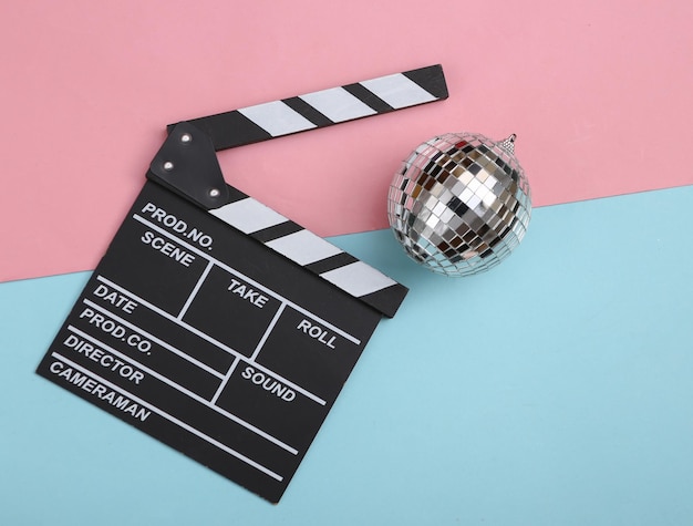 Disco ball with movie board on bluepink background Top view Flat lay Minimalism party concept