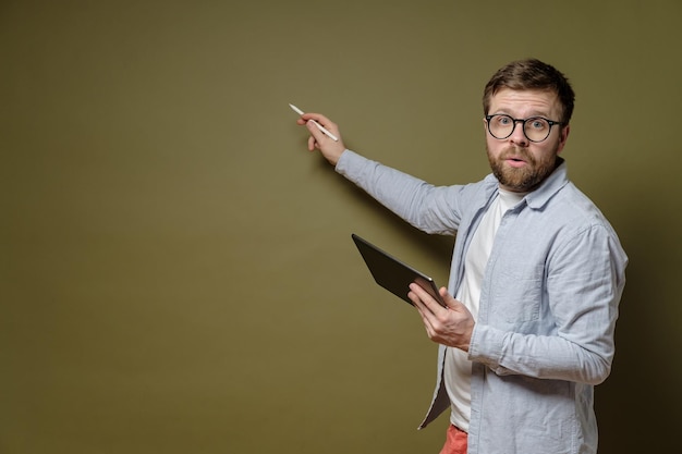 Discussion of the project Concentrated bearded man in glasses with a tablet in hand tells his idea