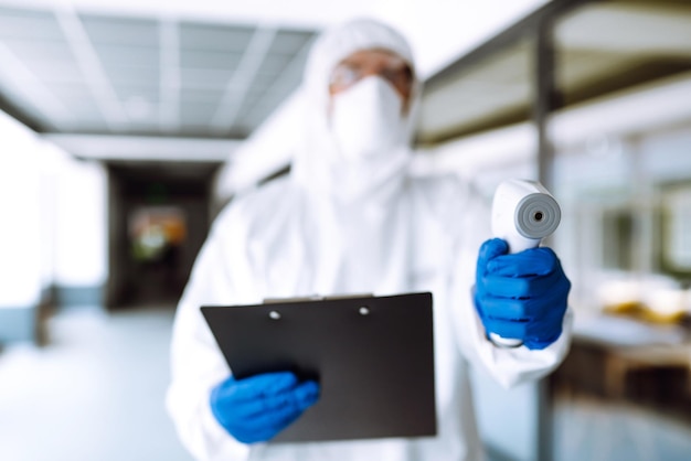 Disease control expert with a equipment to check the temperature at office