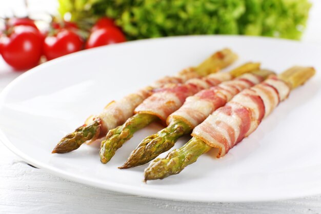 Dish of asparagus and bacon in plate closeup