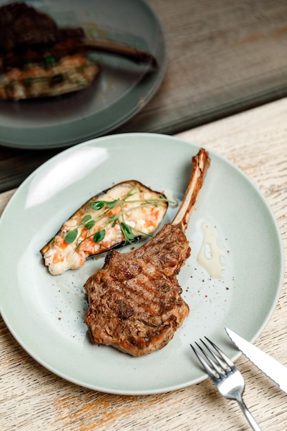 Dish plate with meat steak on the bone in the restaurant