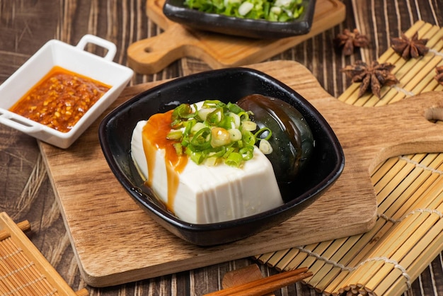 In a dish with chilli sauce isolated on wooden board side view on table taiwan food