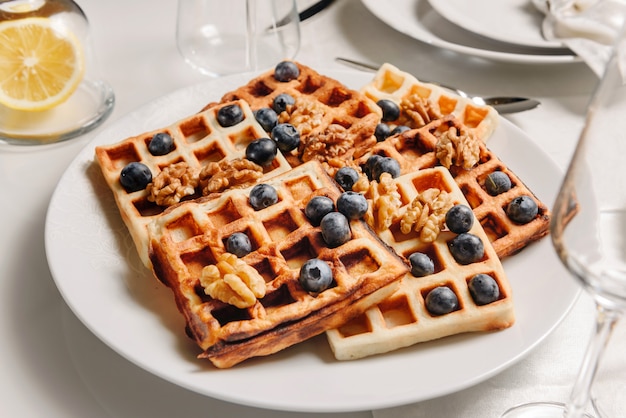 Dish with Viennese waffles decorated with nuts and blueberries.