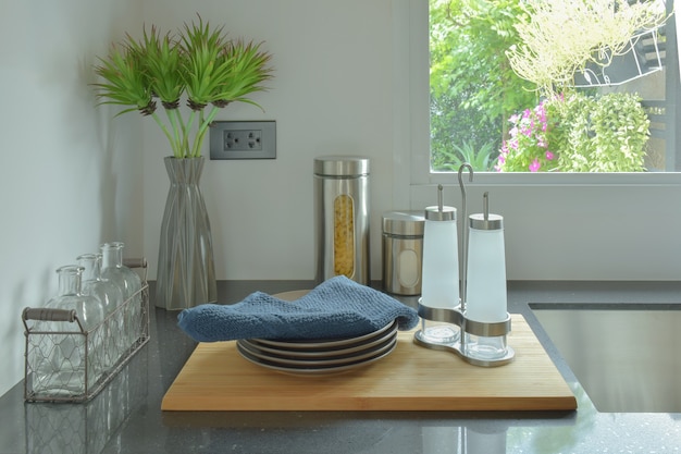 Dishes and glass bottles setting on black counter top in the kitchen