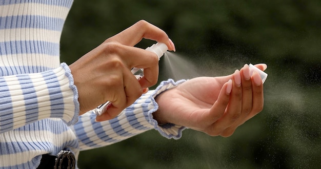 Disinfecting hands on street. Woman sanitaze her hands.