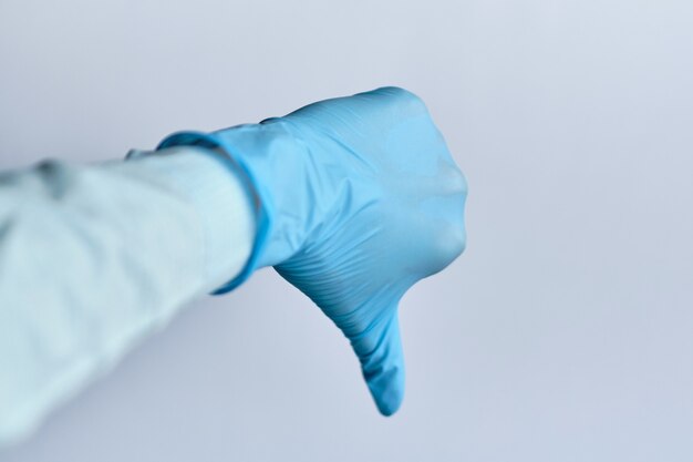 Photo dislike concept - hand in a medical glove on a white space.