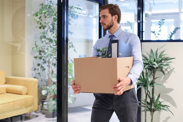 Dismissed worker going from the office with his office supplies.