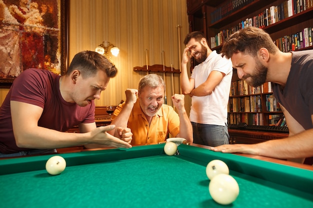 The displeased men playing billiards at office or home after work. Business colleagues involving in recreational activity. Friendship, leisure activity, game concept. Human emotions concepts