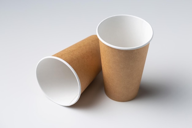 Disposable cardboard biodegradable cups on a white table gray background